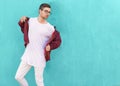 Fashion guy in glasses poses near the wall the color of the sour Royalty Free Stock Photo