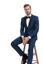 Fashion guy sitting on stool holding his hands together Royalty Free Stock Photo