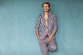 Fashion guy sitting on a blue background in the studio