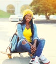 Fashion happy smiling young african woman with skateboard in city Royalty Free Stock Photo