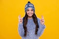 Fashion happy young woman in knitted hat and sweater having fun over colorful blue background. Happy face, positive and Royalty Free Stock Photo