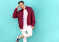 Fashion hipster guy in glasses poses near the wall the color of Royalty Free Stock Photo