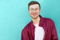 Fashion hipster guy in glasses poses near the wall the color of Royalty Free Stock Photo