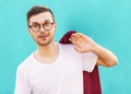 Fashion hipster guy in glasses poses near the wall the color of Royalty Free Stock Photo