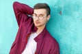 Fashion guy in glasses poses near the wall the color of the sour Royalty Free Stock Photo