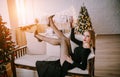 Fashion interior photo of beautiful woman in elegant dress posing near decorated Christmas tree Royalty Free Stock Photo