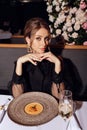 Beautiful woman with dark hair in elegant dress posing in luxury restaurant Royalty Free Stock Photo