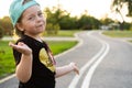 Fashion kid concept - portrait of stylish little cute girl child wearing a cap outdoors in the city. Royalty Free Stock Photo