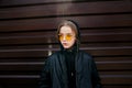 Fashion kid concept - stylish girl child wearing black casual clothes and sunglasses posing summer in the city Royalty Free Stock Photo