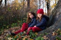 Fashion kids in autumn park. Close up lifestyle portrait of two beautiful caucasian girls outdoors, wearing cute trendy outfit in Royalty Free Stock Photo