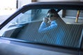 Fashion lady driving a car in a blue suit. Stylish girl sitting in the car and lying on the steering whee Royalty Free Stock Photo