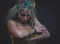 Fashion Latin woman with green hair and gold costume with handmade flourishes, fantasy image and tale