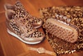 Fashion Leopard sneakers with Glamour golden wristwatch and purse on wooden background.