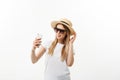 Fashion and Lifestyle Concept: pretty young woman wearing a hat, sunglasses takeing a photo of herself by mobile phone Royalty Free Stock Photo