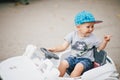 Fashion little boy driving toy car in a park Royalty Free Stock Photo