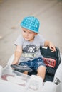 Fashion little boy driving toy car in a park Royalty Free Stock Photo