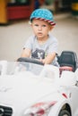 Fashion little boy driving toy car in a park Royalty Free Stock Photo