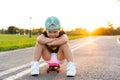 Fashion little girl child sitting on skateboard in city, wearing a sunglasses and t-shirt. Royalty Free Stock Photo