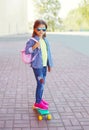 Fashion little girl child with skateboard wearing sunglasses and checkered shirt and backpack Royalty Free Stock Photo