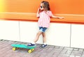 Fashion little girl child with skateboard wearing a sunglasses in city Royalty Free Stock Photo