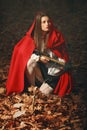 Fashion little red riding hood posing in the forest