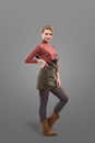 Fashion look of girl dressed in casual style in short skirt and broun boots isolated on grey background