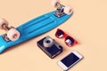 Fashion look concept. Blue skateboard, red sunglasses, vintage camera and screen smartphone