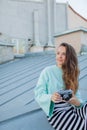 Fashion look, pretty cool young woman model with retro film camera. curly hair outdoors. Stylish girl photographer takes the old c Royalty Free Stock Photo