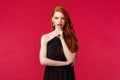 Fashion, luxury and beauty concept. Portrait of attractive sensual and seductive redhead woman in elegant black dress Royalty Free Stock Photo