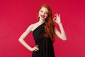 Fashion, luxury and beauty concept. Portrait of satisfied coquettish pretty redhead woman in elegant black dress Royalty Free Stock Photo