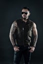 Fashion macho in trendy sunglasses. Tattoo model with beard on unshaven face. Bearded man with tattoo on strong arms Royalty Free Stock Photo