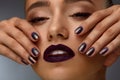 Fashion Makeup. Beautiful Woman With Dark Lips And Purple Nails Royalty Free Stock Photo