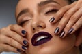 Fashion Makeup. Beautiful Woman With Dark Lips And Purple Nails Royalty Free Stock Photo