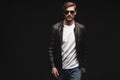 Fashion man, Handsome beauty male model portrait wear sunglasses and leather jacket, young guy over black background. Royalty Free Stock Photo