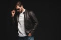 Fashion man, Handsome beauty male model portrait wear sunglasses and leather jacket, young guy over black background. Royalty Free Stock Photo