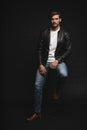 Fashion man, Handsome serious beauty male model portrait wear leather jacket, young guy over black background. Royalty Free Stock Photo