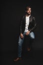 Fashion man, Handsome serious beauty male model portrait wear leather jacket, young guy over black background. Royalty Free Stock Photo