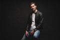 Fashion man, Handsome serious beauty male model portrait wear leather jacket, young guy over black background. Royalty Free Stock Photo