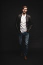 Fashion man, Handsome serious beauty male model portrait wear leather jacket, young guy over black background. Royalty Free Stock Photo