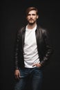 Fashion man, Handsome serious beauty male model portrait wear leather jacket, young guy over black background. Royalty Free Stock Photo