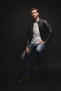 Fashion man, Handsome serious beauty male model portrait wear leather jacket, young guy over black background. Royalty Free Stock Photo