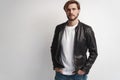 Fashion man, Handsome serious beauty male model portrait wear leather jacket, young guy over white background. Royalty Free Stock Photo