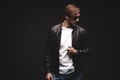 Fashion man, Handsome beauty male model portrait wear sunglasses and leather jacket, young guy over black background. Royalty Free Stock Photo