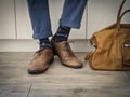 Fashion man legs in indigo navy blue pants, navy anchor socks, leather shoes and leather tote bag