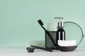 Fashion men toiletry accessories in black color in green mint menthe and white interior - razor, mirror, towel, soap, toothbrush.