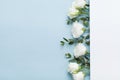 Fashion mockup of paper card decorated beautiful white flowers and eucalyptus leaves on pastel background top view. Flat lay.