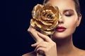 Fashion Model Beauty Portrait with Gold Rose Flower, Golden Woman Luxury Makeup an Rose Jewelry Royalty Free Stock Photo