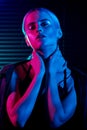 Fashion model blonde woman in colorful bright neon lights posing in studio. Royalty Free Stock Photo