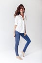 Fashion model in a blouse and jeans barefoot