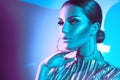 Fashion model brunette woman in colorful bright neon lights. Beautiful girl, trendy glowing makeup, metallic silver lips